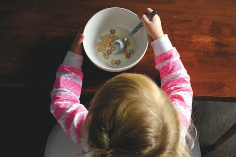 photo of child eating breakfast in article about designing a stress-free morning routine with young children