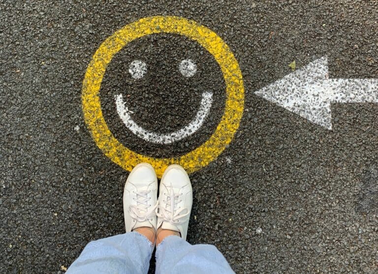photo of woman standing on happy face emoji to illustrate article on working mum's guilt