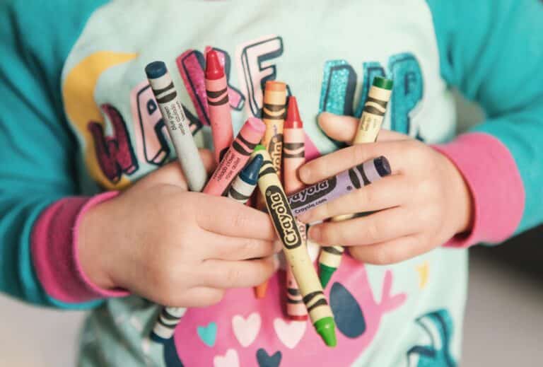 photo of child holding crayons - one of the best toys to buy for children!