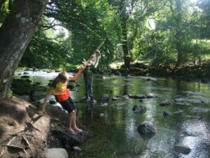 photo of children playing on a rope swing over a river