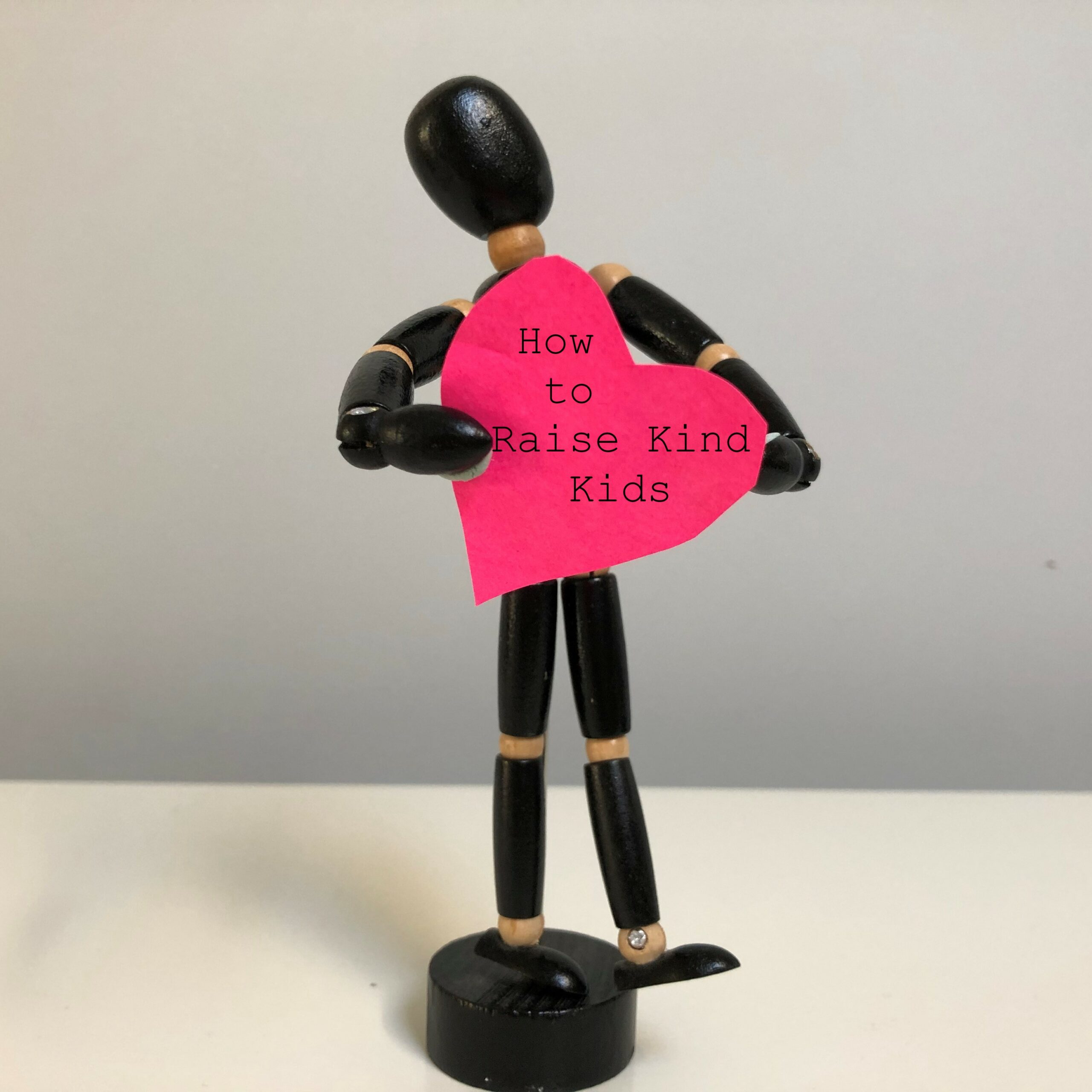 stick man holding heart saying Raising Kind Kids