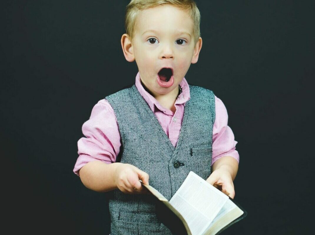 photo of young boy reading book, children's books on lying article