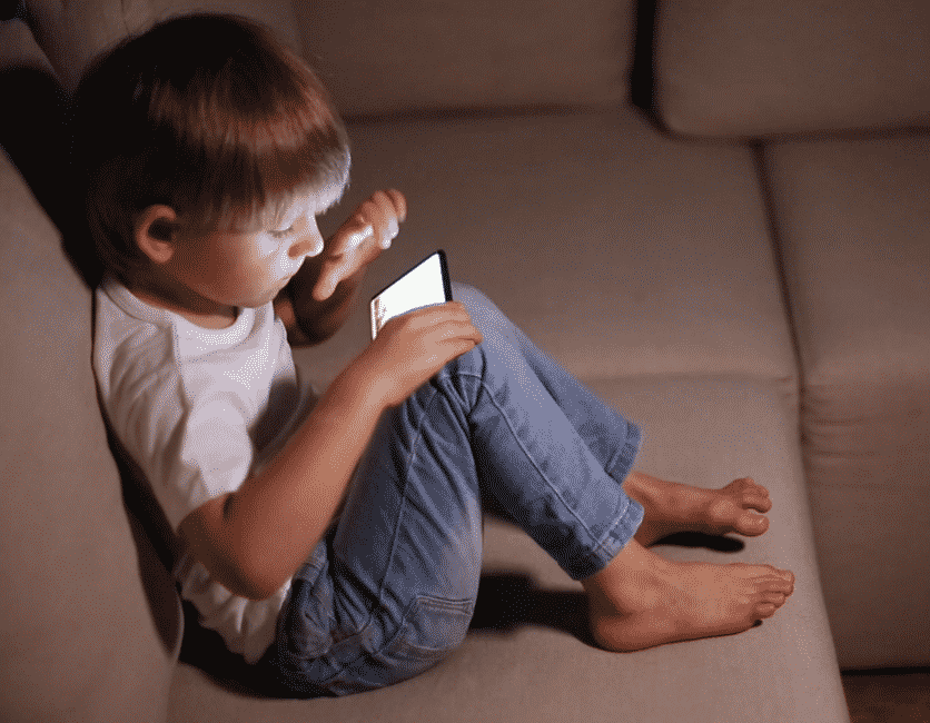 photo of child playing on phone to illustrate blog by parenting expert Anita Cleare on How much tech time is too much tech time?