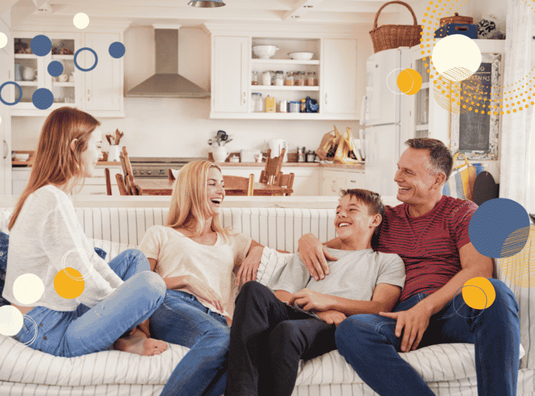 photo of smiling mum, dad and two teenagers sitting on a sofa to illustrate article by Helen Beedham on how to negotiate boundaries to protect family time