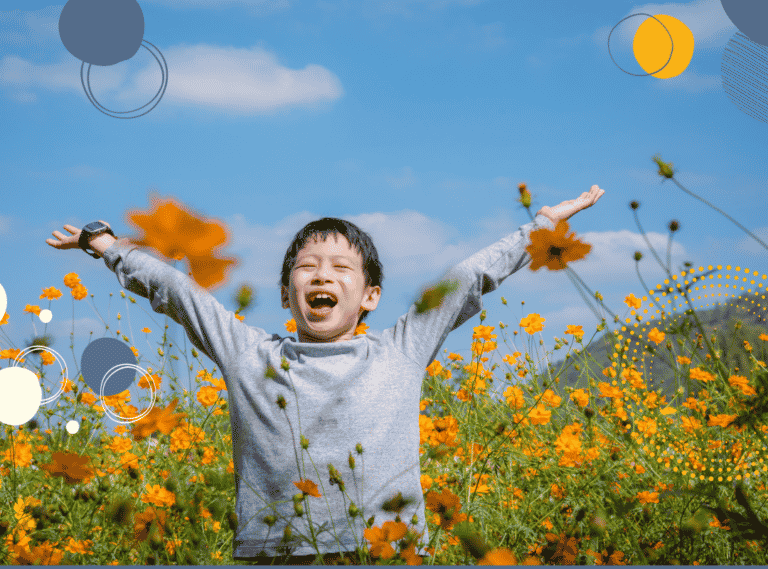 photo of happy young boy in a field with his hands in the air to illustrate suggestions of activities to build children's confidence