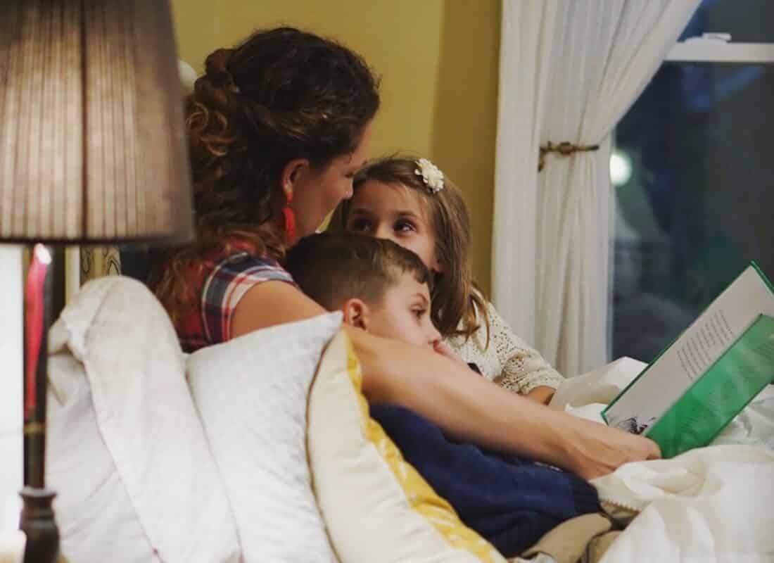 mum reading story to two children