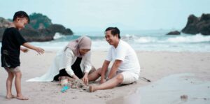 picture of family on a beach playing in the sand together