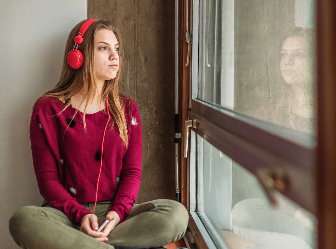 Teen girl wearing headphones and looking away to illustrate parenting webinar on How to get your teenager out of their bedroom