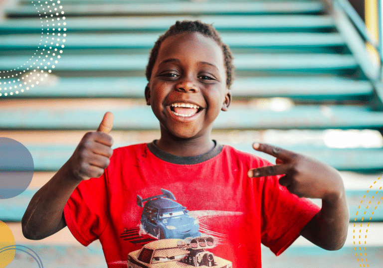 Photo of young boy smiling at the camera and looking happy to illustrate article on how temperament impacts children's development