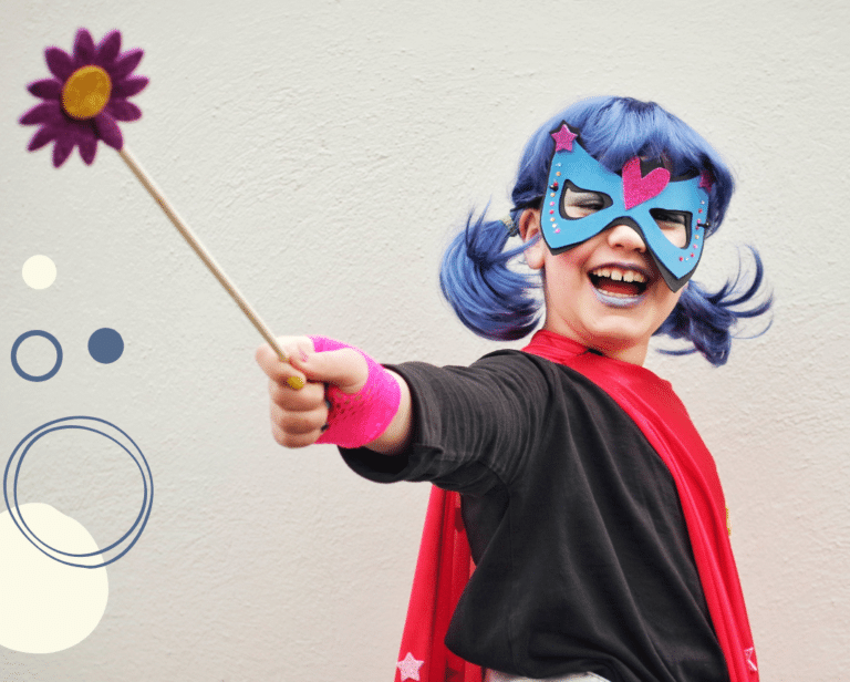 Photo of young girl with blue hair where a mask and a cape and holding out a flower like or wand to illustrate tips on parenting a child with ADHD