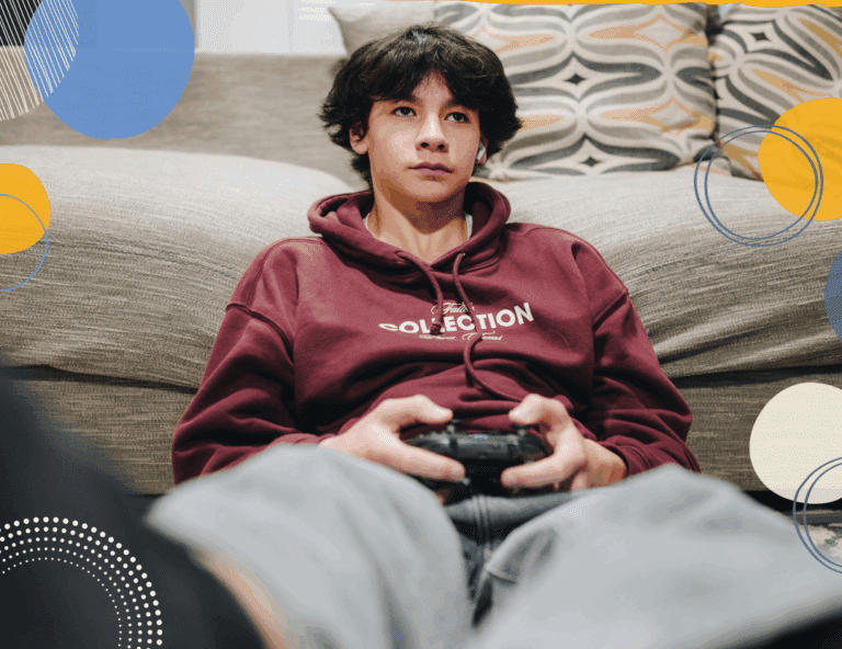Photo of teen boy playing a video game to illustrate article for parents on setting screentime limits for teens over the school holidays
